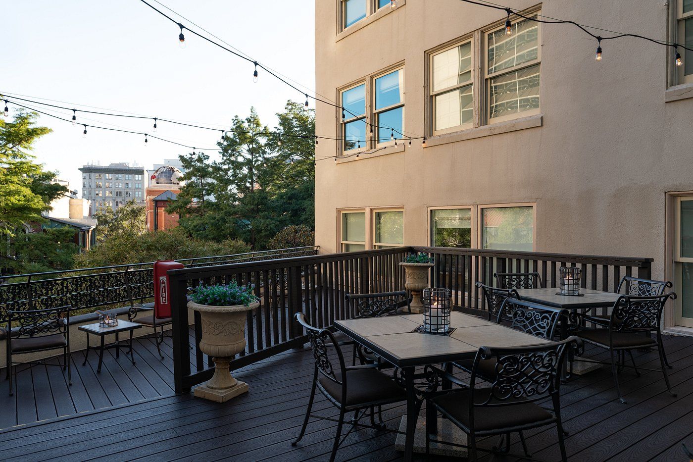 A deck with outdoor seating, string lights, and a fire extinguisher.