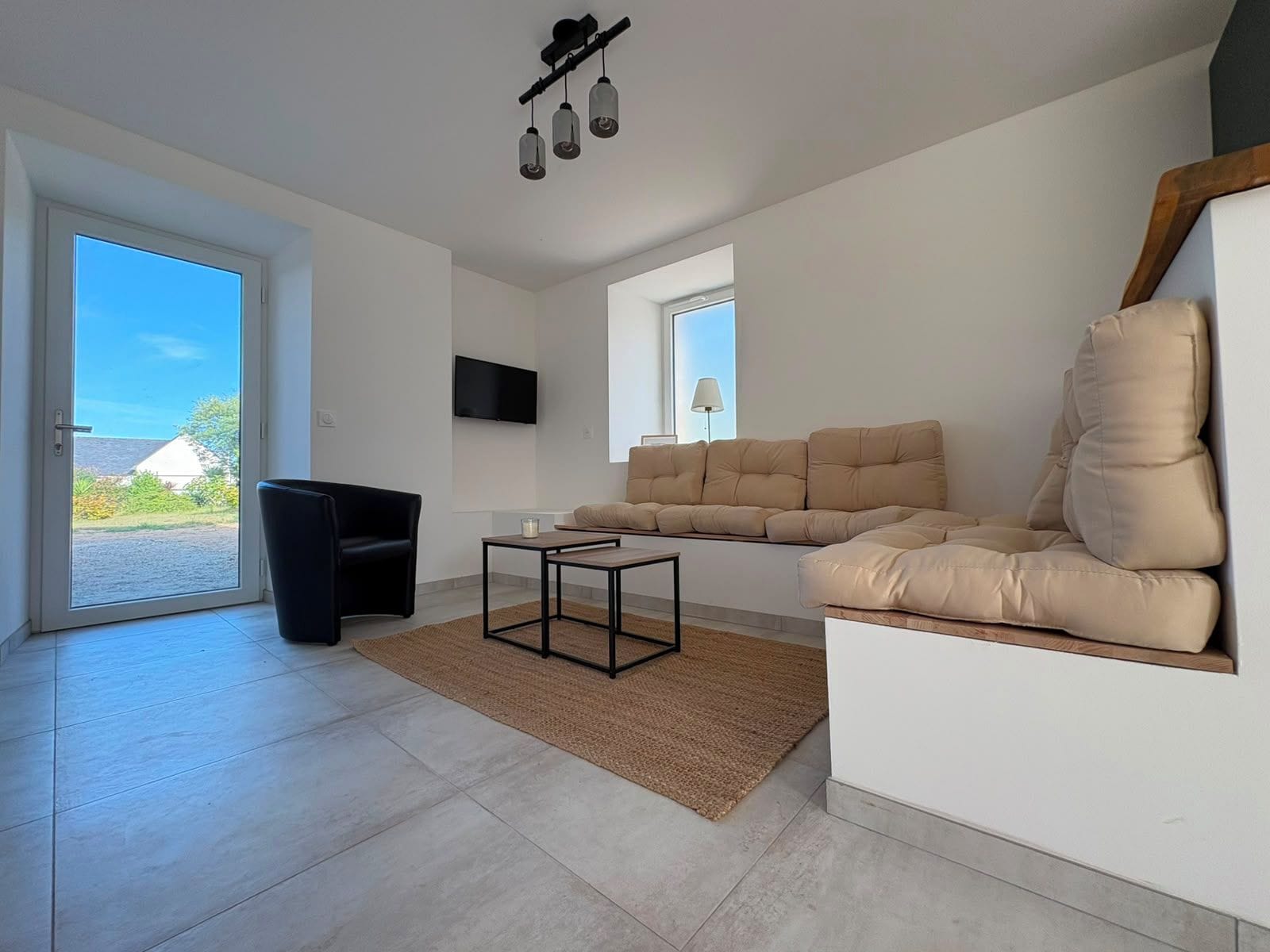 A modern living room with a sofa, a coffee table, and a television.