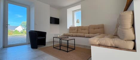 A modern living room with a sofa, a coffee table, and a television.