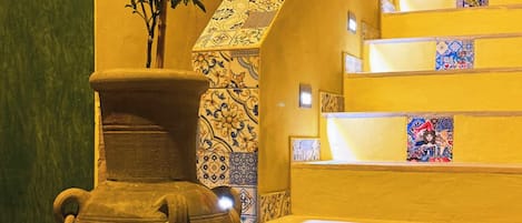A staircase with a decorative vase and a potted plant.