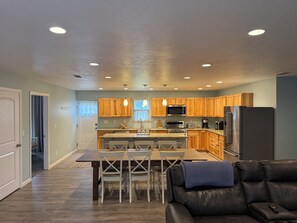 A modern kitchen with wooden cabinets, stainless steel appliances, and a dining area with a table and chairs. - Open 2 Bedroom Condo Floorplan with RV Parking near University of Notre Dame (Niles)