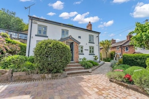 A two-story house with a front garden, a paved driveway, and a clear blue sky. - 31 Old Chester Road (Helsby)