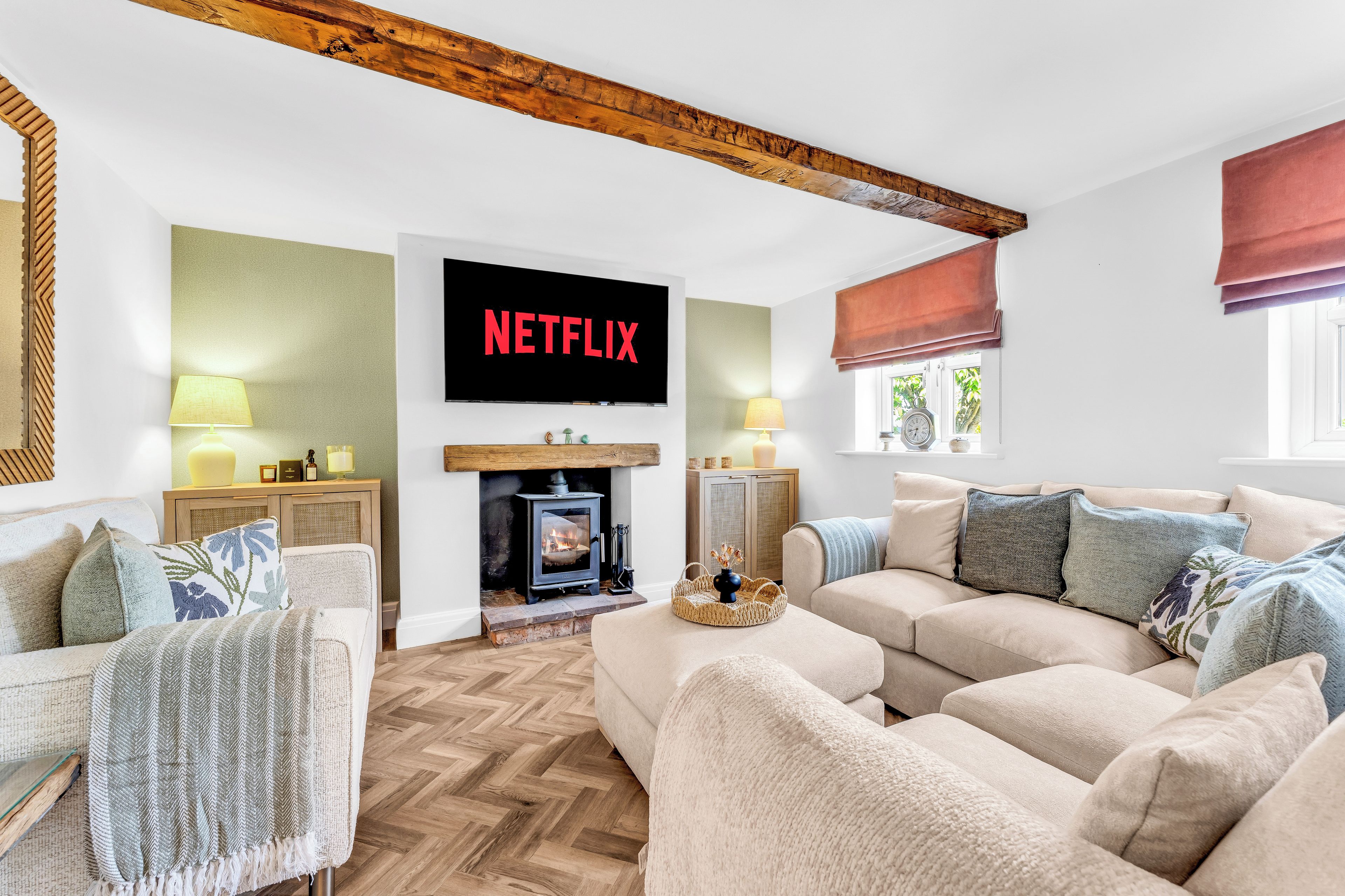 A cozy living room with a fireplace, a television mounted on the wall, and a comfortable sofa.