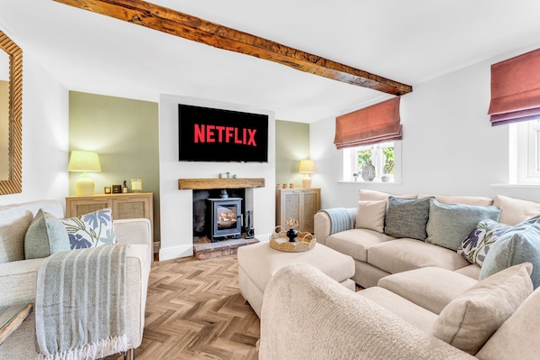 A cozy living room with a fireplace, a television mounted on the wall, and a comfortable sofa. - 31 Old Chester Road (Helsby)
