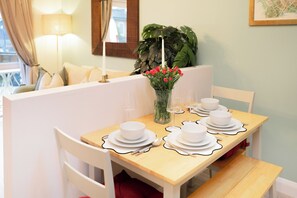 A dining area with a table set for four, white plates, and clear glassware. - 31 Old Chester Road (Helsby)