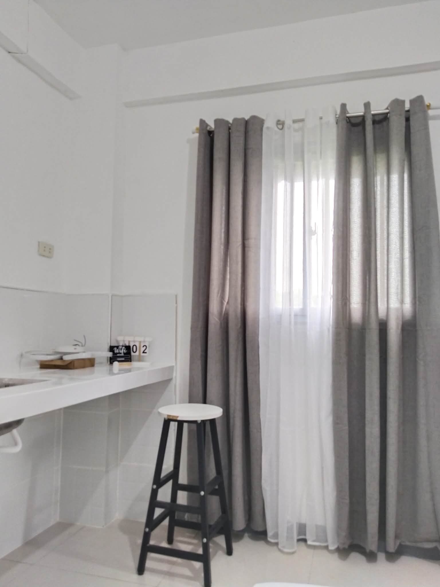 A bathroom with a white sink, a mirror, a towel rack, and a stool.