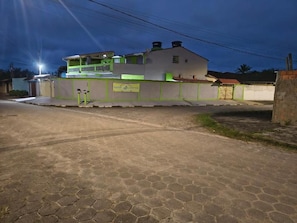 A building with a flat roof, a balcony, and a sign on the wall. - Pousada do Sossego Mar e Verde 1 (Itanhaem)