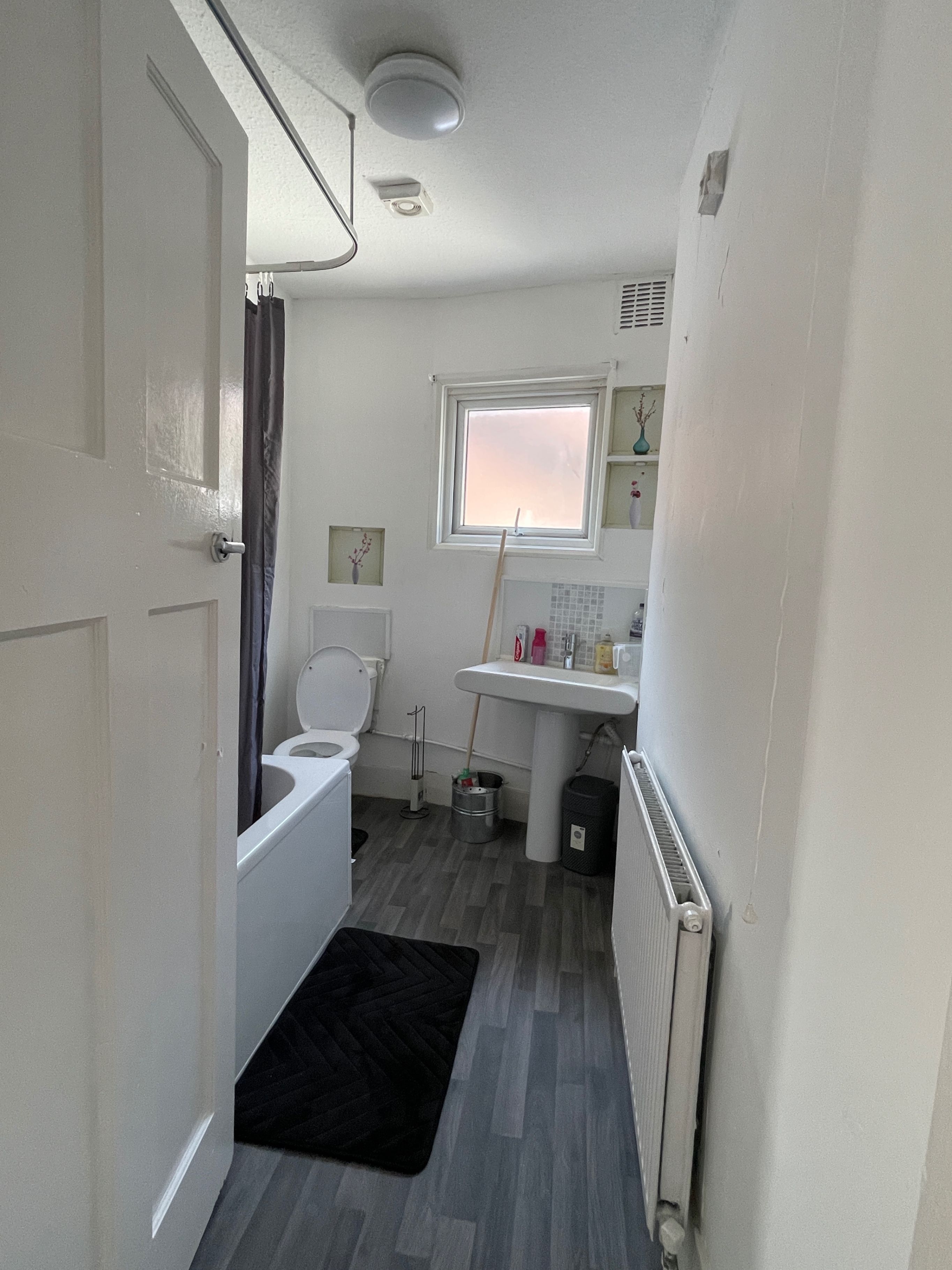 Un baño pequeño con inodoro, lavamanos y zona de ducha.