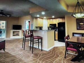 A spacious living area with a kitchen, dining table, and chairs. - Club Wyndham Palm-Aire 2 Bedroom, 2 Bath - Pampering Encouraged! (Pompano Beach)