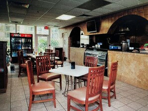 A restaurant interior with booths and tables, a counter with a cash register, and a soda machine. - Club Wyndham Palm-Aire 2 Bedroom, 2 Bath - Pampering Encouraged! (Pompano Beach)