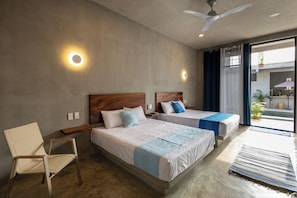 A hotel room with two beds, a chair, a ceiling fan, and a view of the outdoors. - Casa Oceana (Brisas de Zicatela)
