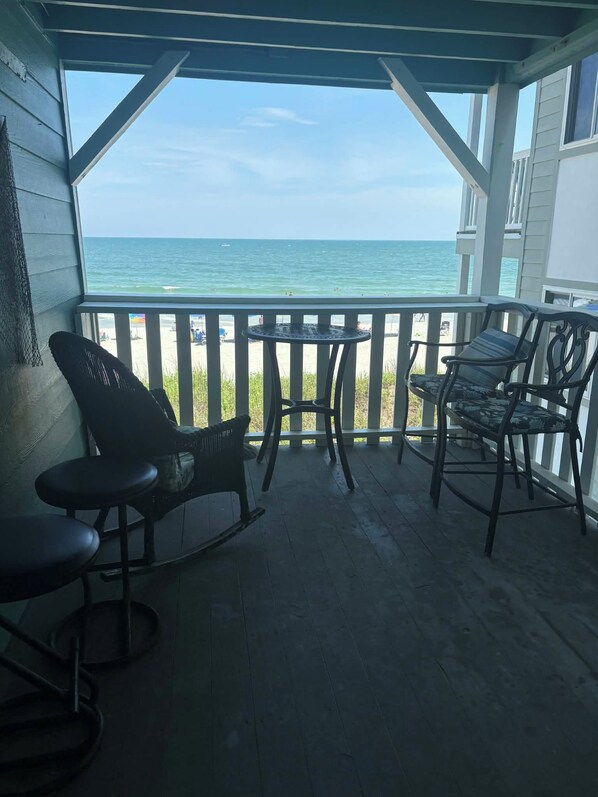 A covered outdoor seating area with a view of the ocean. - Right at garden city pier and ocean front 2 bedroom 2 bath (Murrells Inlet)