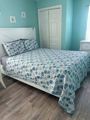 Ein Bett mit Blumendekoration, einem weißen Kopfteil und einem Holzboden.