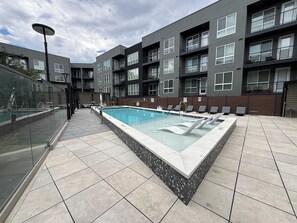 A modern apartment complex with a swimming pool, outdoor seating, and a glass-enclosed balcony. - U of U, Convention, Pool & Hot Tub, Gym (Salt Lake City)