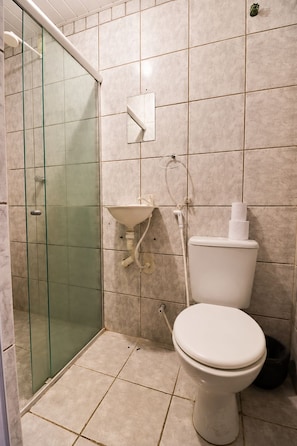 Ein Badezimmer mit einer Duschkabine, einer Toilette und einem Waschbecken.
