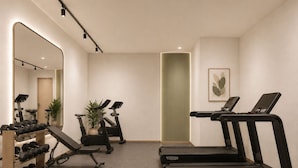 Ein Fitnessstudio mit Laufbändern, Gewichten und Trainingsgeräten.