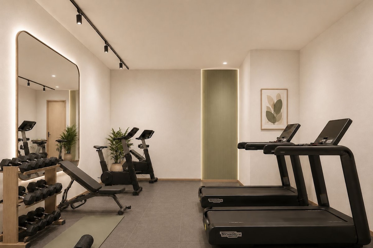 Un gimnasio con cintas de correr, pesas y equipamiento de ejercicio.
