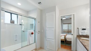Un bagno moderno con doccia vetrata, un water e un lavabo con piano.
