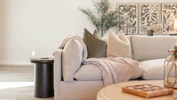 A modern living room with a sofa, a round coffee table, and decorative wall art.