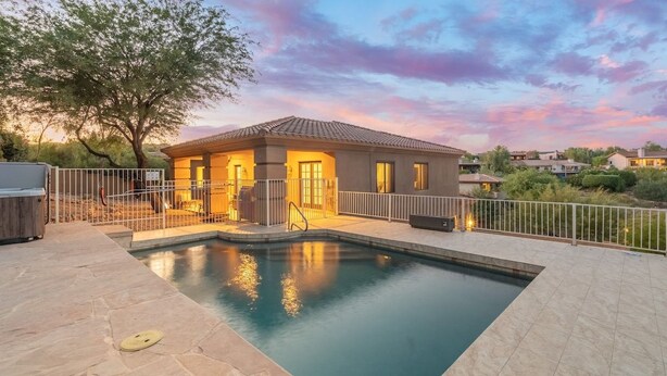 Un immobile residenziale con piscina, patio recintato e una casa con tetto in tegole.