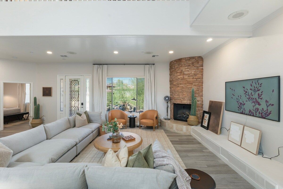 A modern living room with a sofa, coffee table, and fireplace.