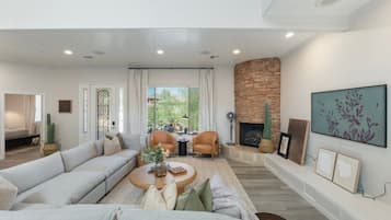 A modern living room with a sofa, coffee table, and fireplace.