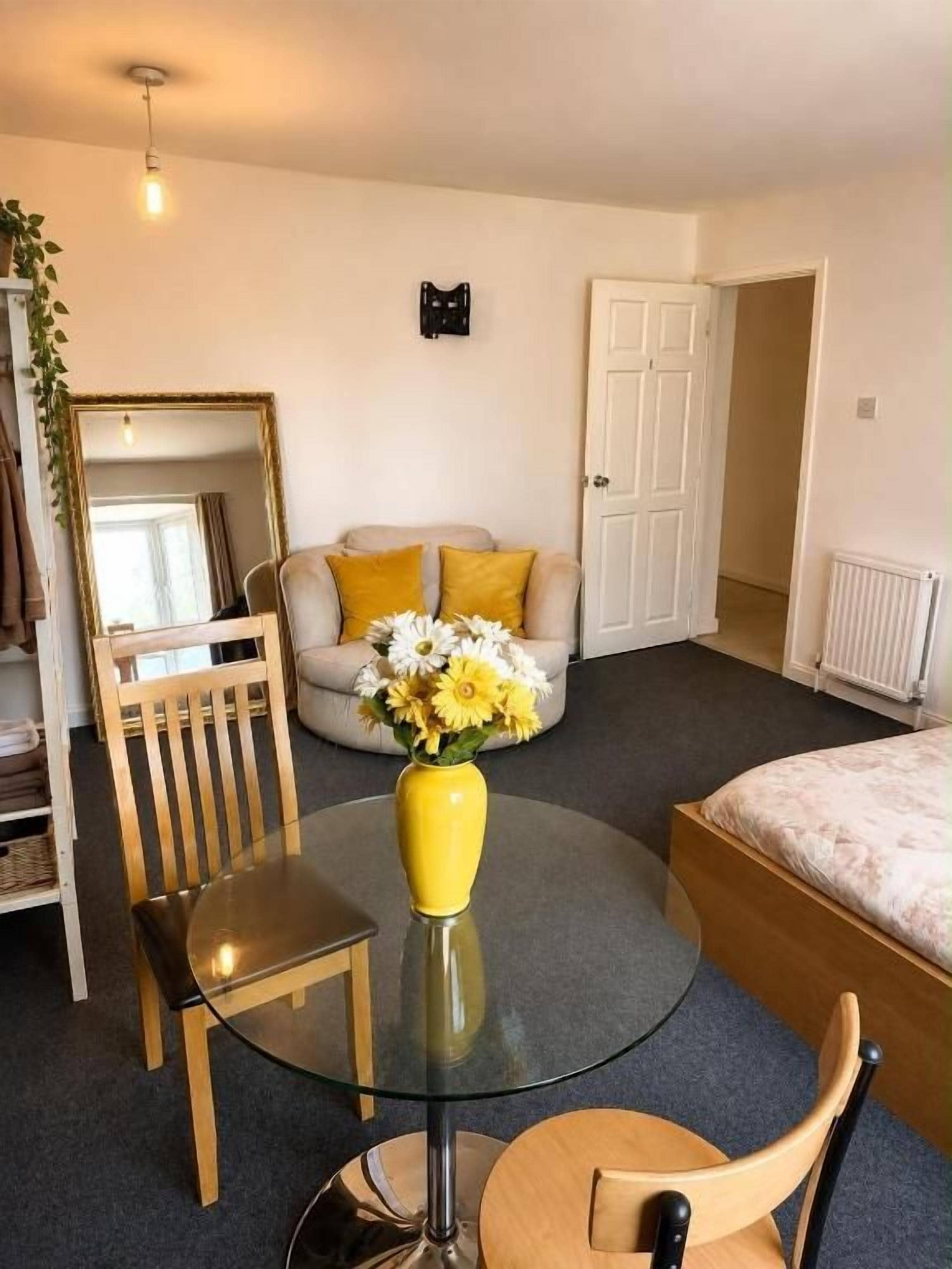Une pièce comprenant une table ronde en verre, une chaise, un lit, une armoire et une porte.