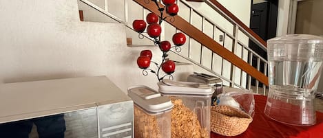 A breakfast bar with food containers and a red decorative element.