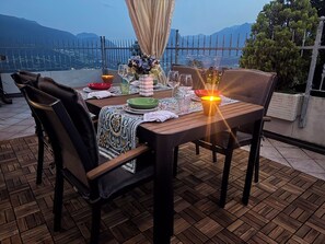 Zona pranzo all'aperto con tavolo apparecchiato per due, con vista panoramica.