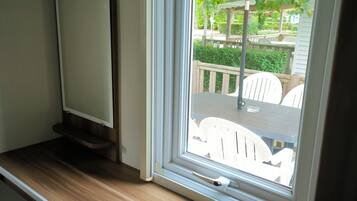 A window with a view of outdoor furniture and greenery.