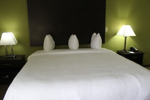 Habitació d'hotel amb un llit gran, dues taules de nit i dues làmpades.