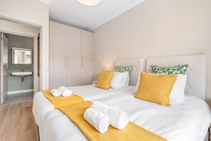 Ein Hotelzimmer mit zwei Betten, einem Badezimmer und einem Flur.