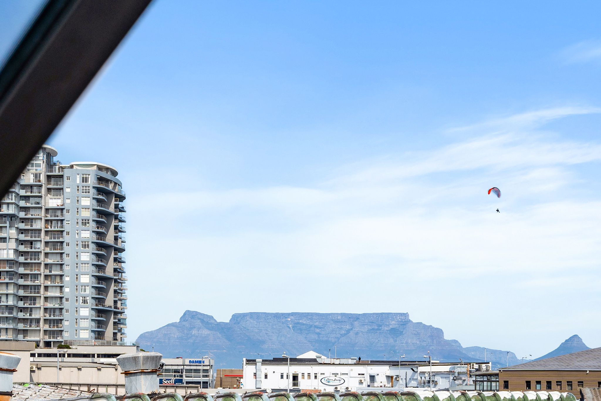 A high-rise building with a clear view of a mountain in the background.