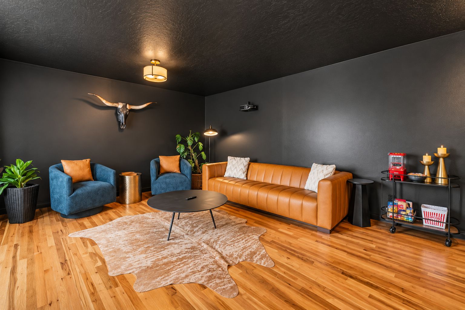 A modern living room with a leather sofa, two armchairs, a coffee table, and a wooden floor.