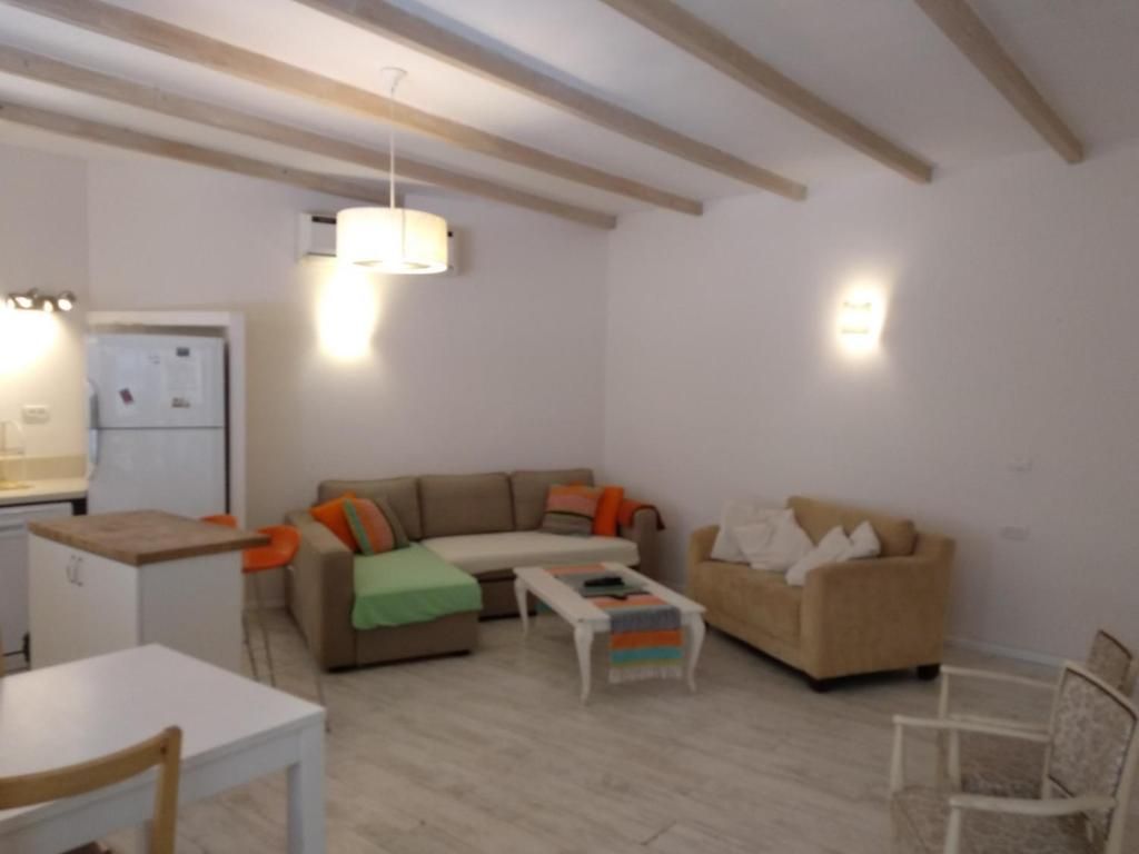 Uma sala de estar com sofá, mesa de centro e mesa de jantar.