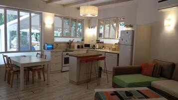 A compact kitchen with a dining area, a sofa, and a small table.