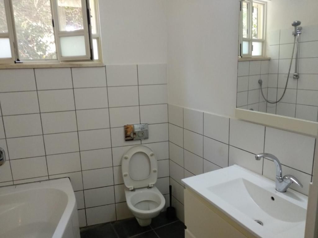 A bathroom with a toilet, sink, and bathtub.