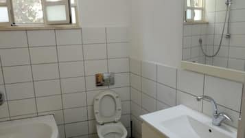 A bathroom with a toilet, sink, and bathtub.