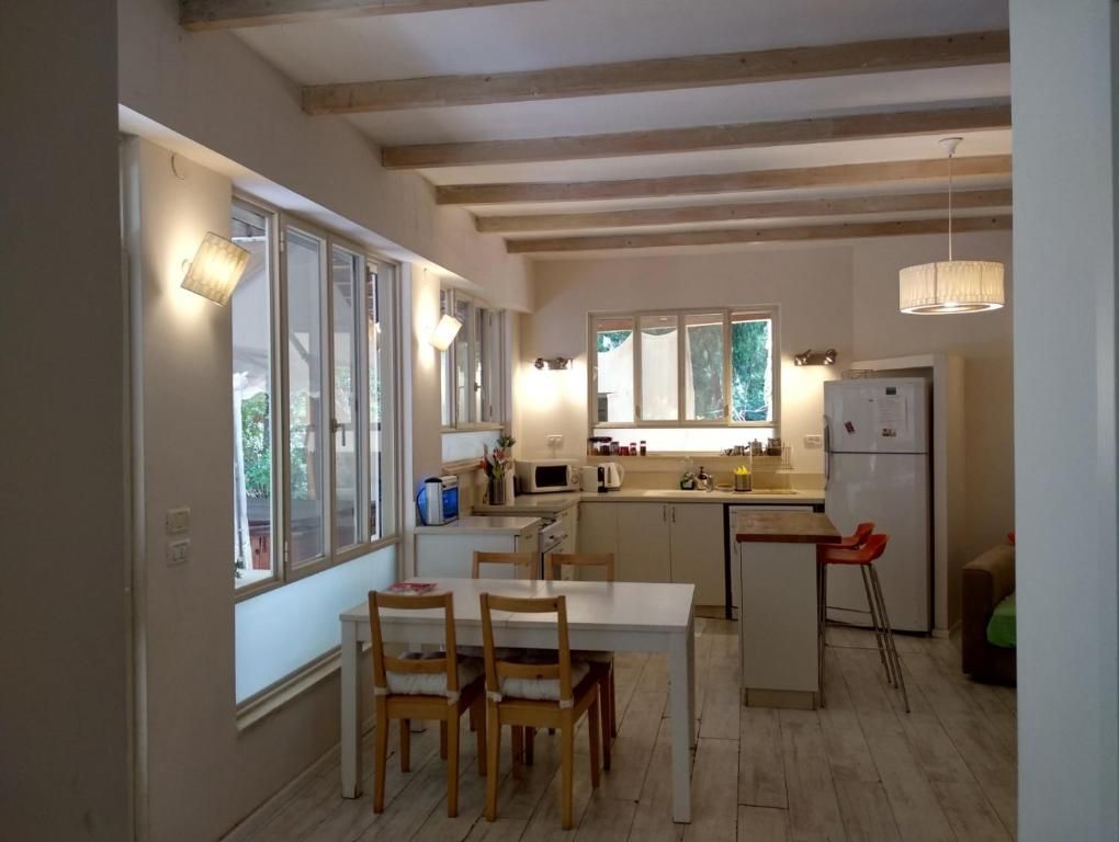Una cocina con vigas de madera, una mesa de comedor con sillas y un refrigerador.
