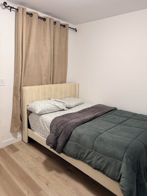 A bed with a headboard, a blanket, and a pillow. - Spacious well equipped bedroom and private washroom with a private entrance. (Winnipeg)