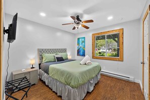 A bedroom with a bed, a ceiling fan, a window with blinds, and a painting on the wall. - Saw Creek 4-Bed Mountain Escape w/fire pit (Saw Creek)