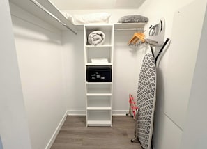 A small, white closet with shelves, a hanging rack, and a microwave. - Modern Gorgeous 2BR - Beachwalk Bay View & Access (Hallandale Beach)
