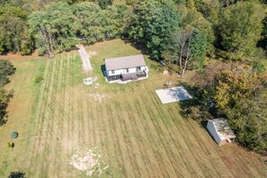 A single-story house with a fenced yard, a small shed, and a clear sky. - Family-Friendly 4BR Home with Acreage in Addison (Addison)