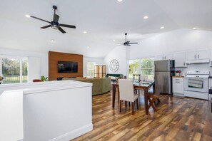 A modern kitchen with wooden flooring, white cabinetry, and a central island. - Family-Friendly 4BR Home with Acreage in Addison (Addison)