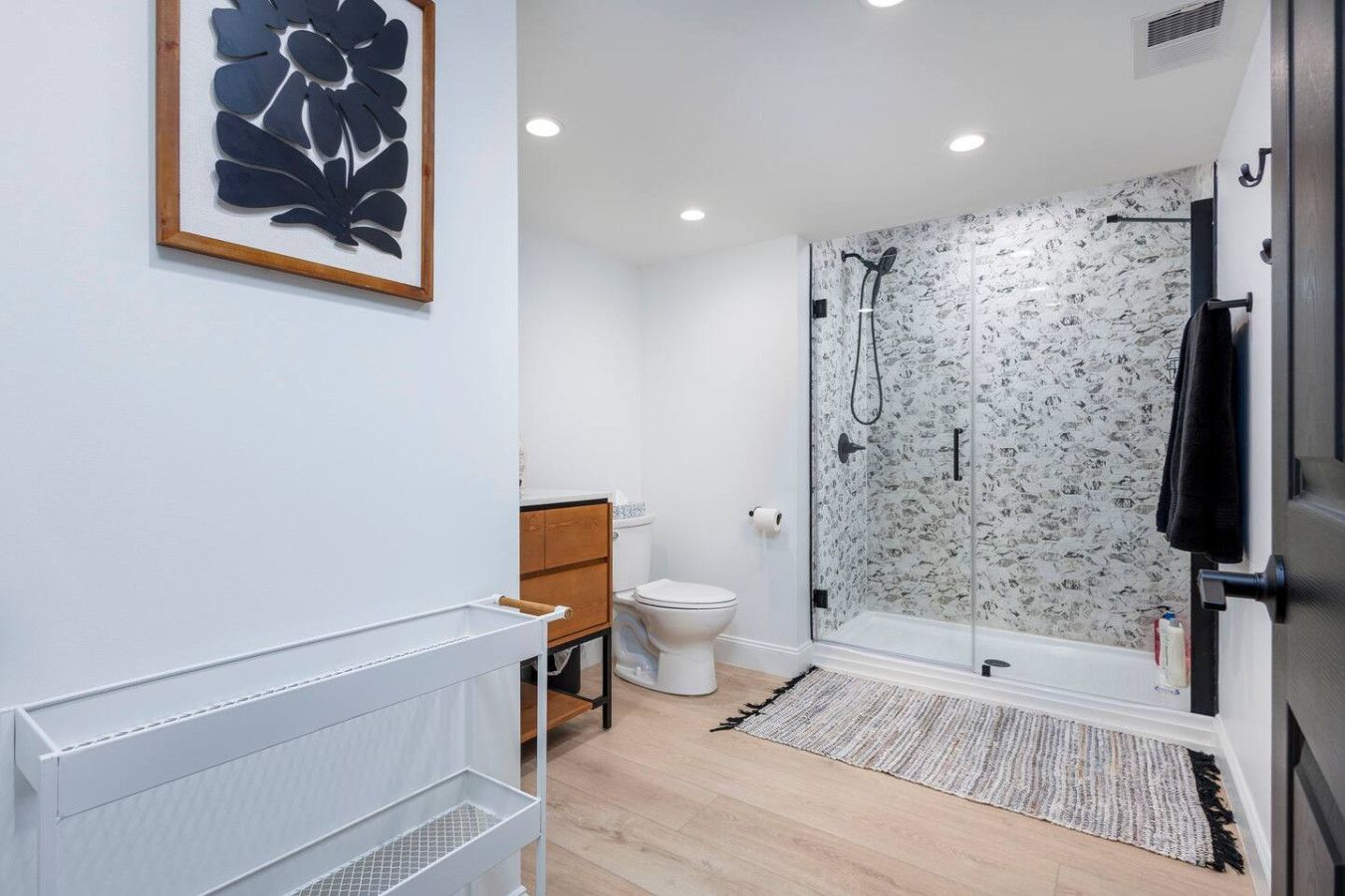 A modern bathroom with a shower, toilet, and a radiator.