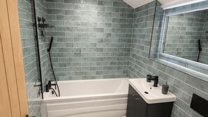 A bathroom with a bathtub, a toilet, and a sink.