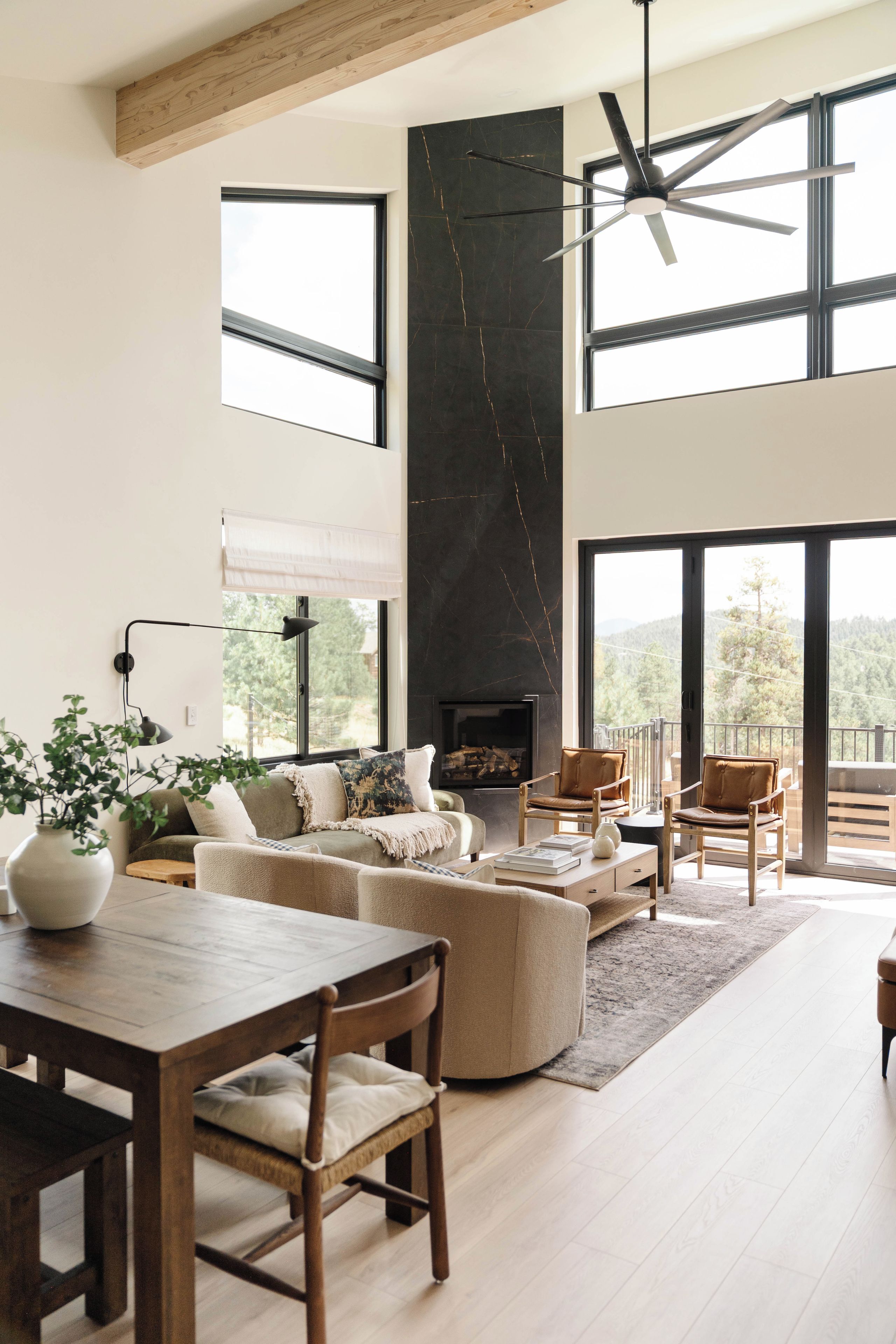 Un salón amplio con chimenea, ventanas grandes y un techo alto.