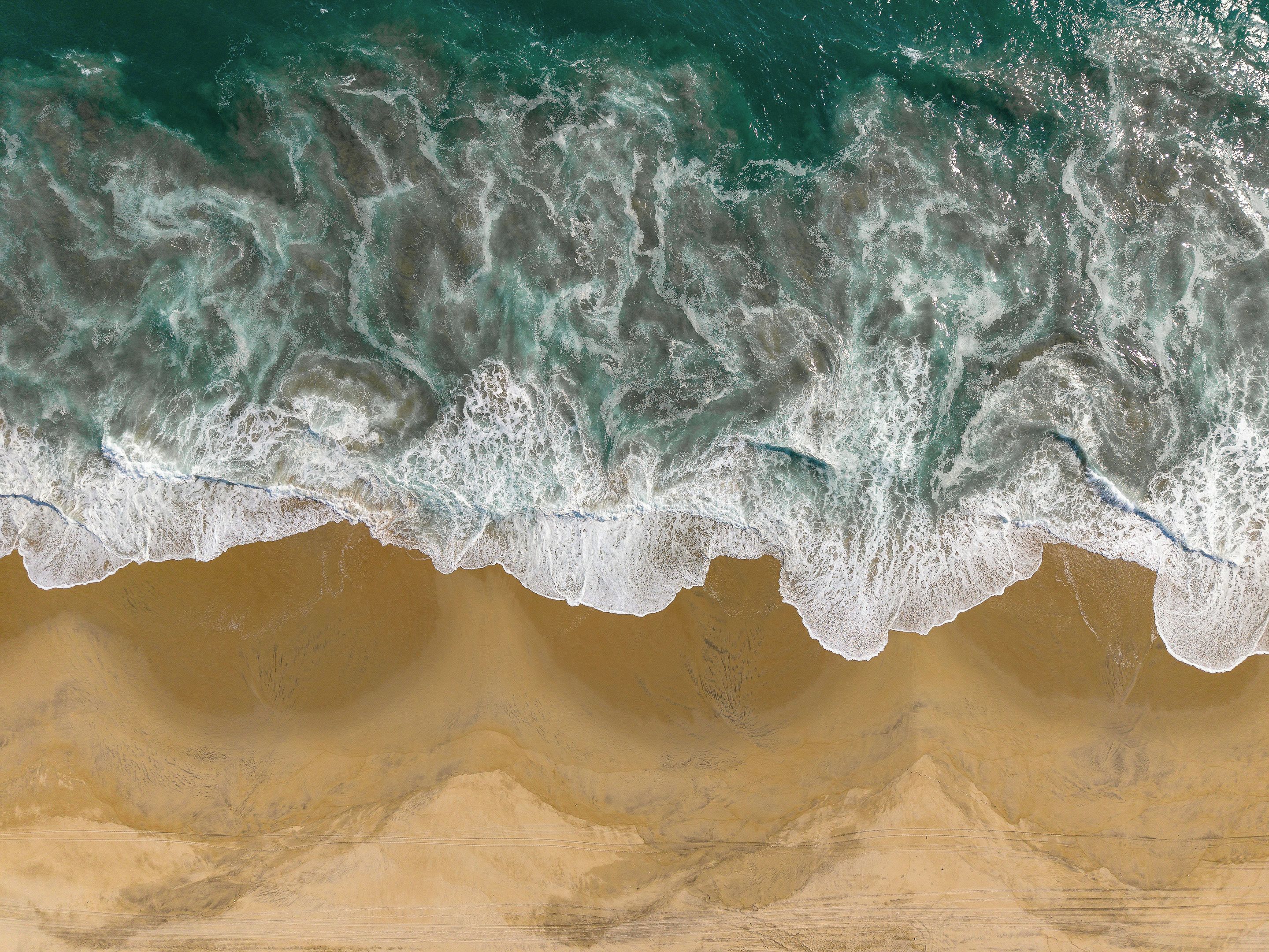 Una playa con olas rompiendo sobre la orilla.