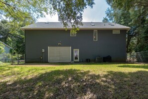 Einbungalow mit Garage, überdachter Terrasse und umzäunter Garten.