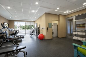 A gym with exercise equipment, a red exercise ball, and a wall-mounted phone. - Home2 Suites by Hilton Wheat Ridge Golden (Wheat Ridge)